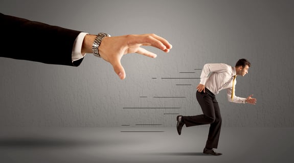 Businessman running away from a huge hand concept on background